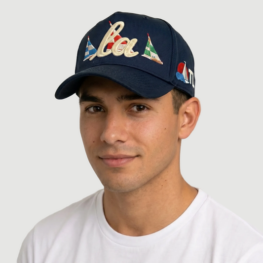 Person wearing a navy blue cap with colorful designs on a plain background