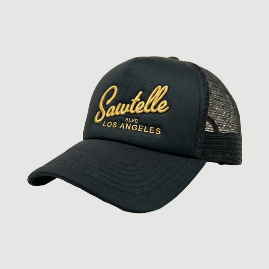 Black cap with gold 'Sawtelle Blvd Los Angeles' text on a beige background